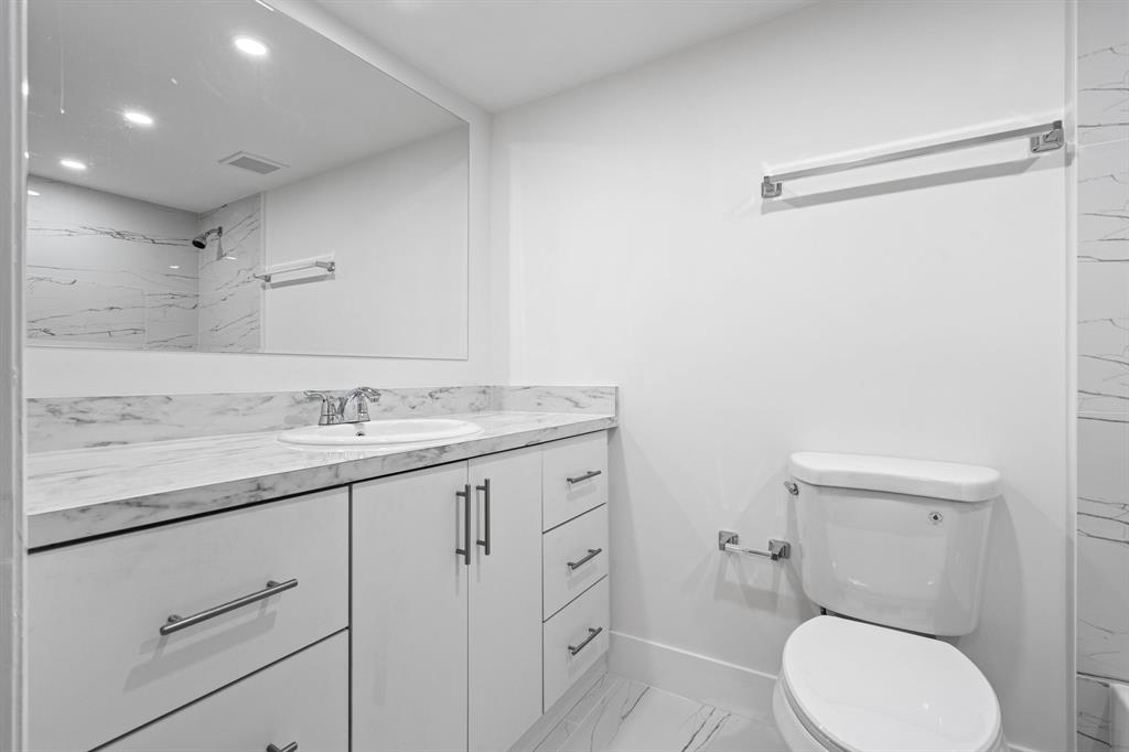 5700 Southwest 127th Avenue, Unit 1304 Miami, FL 33183 - Photo 5 of 42 a bathroom with a granite countertop toilet sink and mirror