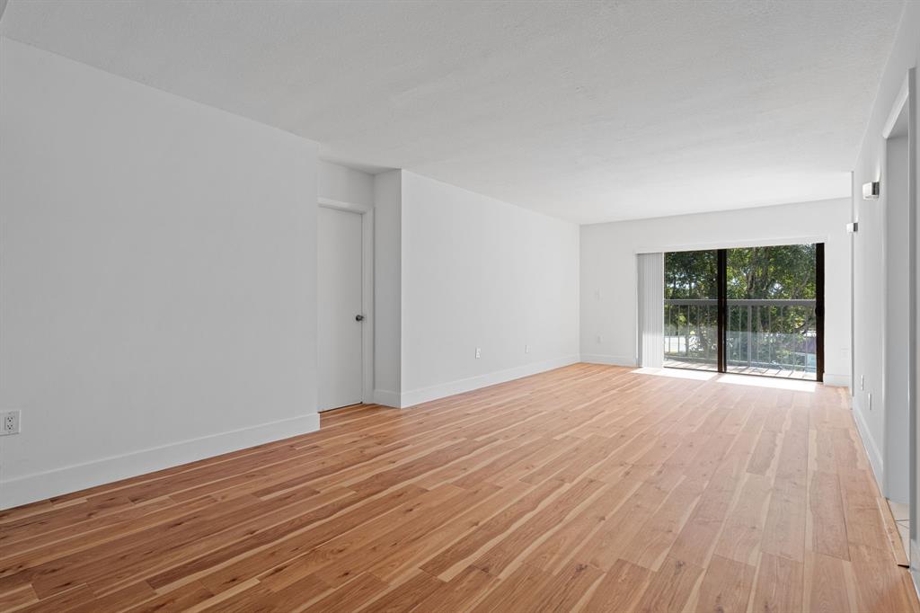 5700 Southwest 127th Avenue, Unit 1304 Miami, FL 33183 - Photo 7 of 42 a view of an empty room with wooden floor and a window