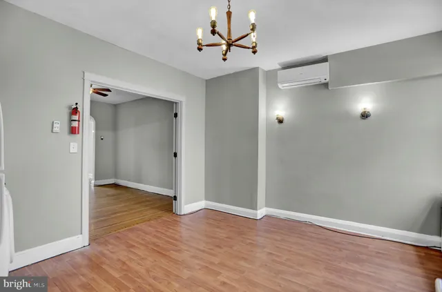 an empty room with wooden floor and a ceiling fan