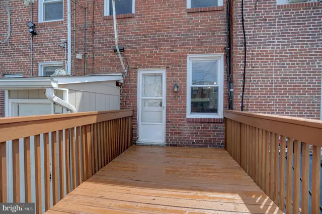 a view of a brick house with wooden fence