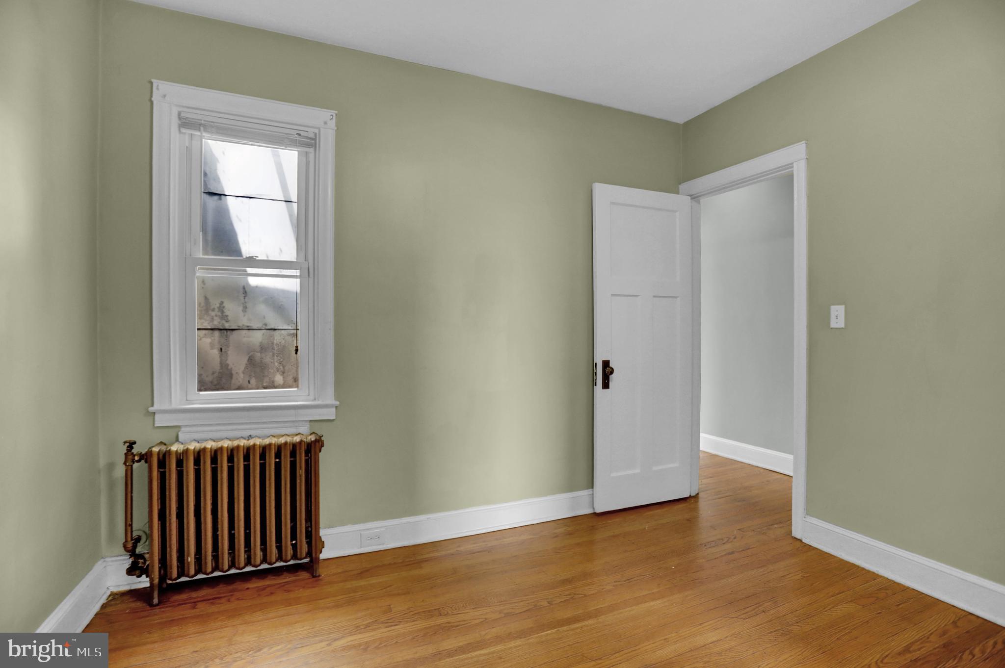434 Folcroft Street, Unit A Baltimore, MD 21224 - Photo 7 of 22 an empty room with wooden floor and windows