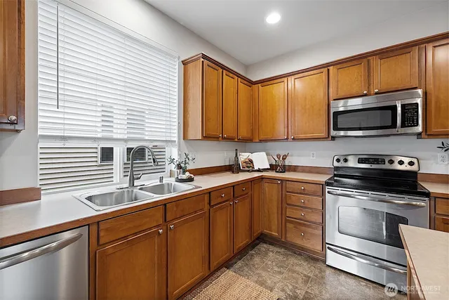 a kitchen with a sink stove top oven and microwave