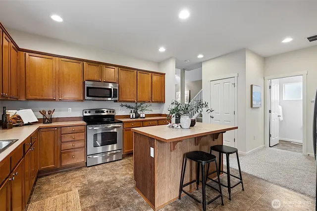 a kitchen with stainless steel appliances kitchen island granite countertop a sink and cabinets