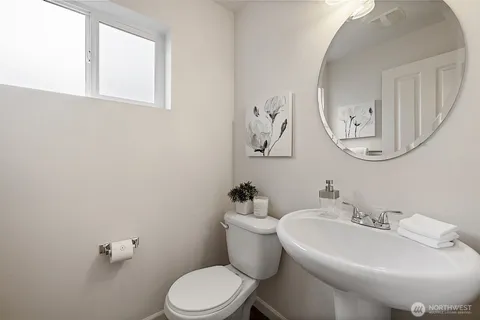 a bathroom with a toilet a sink and mirror