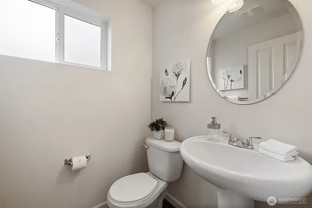 a bathroom with a toilet a sink and mirror