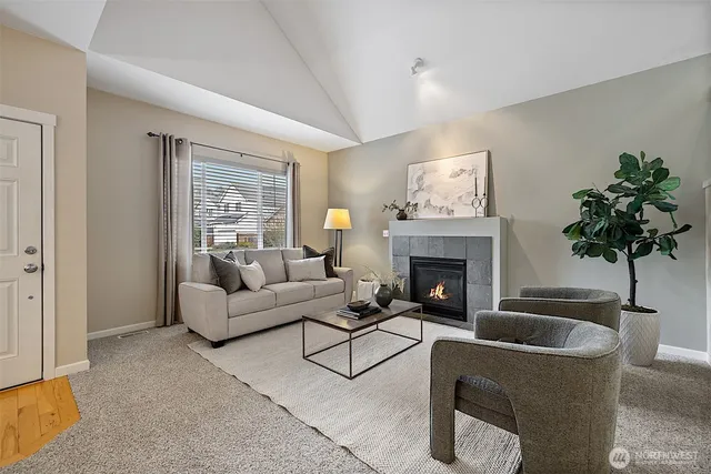 a living room with furniture a fireplace and potted plants