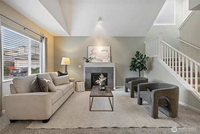a living room with furniture a fireplace and a potted plant