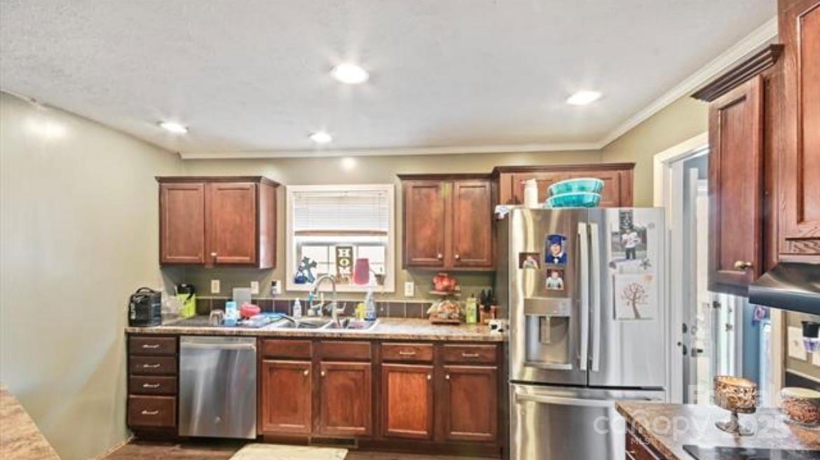 116 Kings Glen Road Old Fort, NC 28762 - Photo 7 of 16 a kitchen with stainless steel appliances a refrigerator sink and cabinets