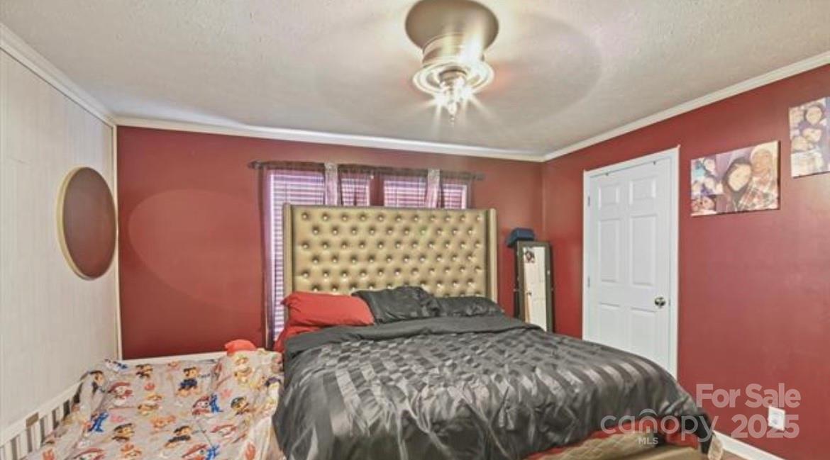 116 Kings Glen Road Old Fort, NC 28762 - Photo 9 of 16 a bedroom with a bed and a chandelier