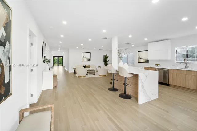 a large white kitchen with lots of counter space wooden floor and appliances