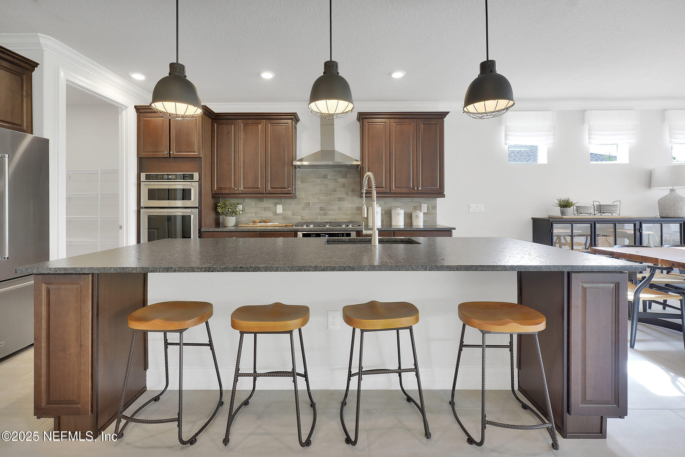334 Continuum Loop Yulee, FL 32097 - Photo 5 of 37 a kitchen with stainless steel appliances granite countertop a dining table chairs sink and microwave