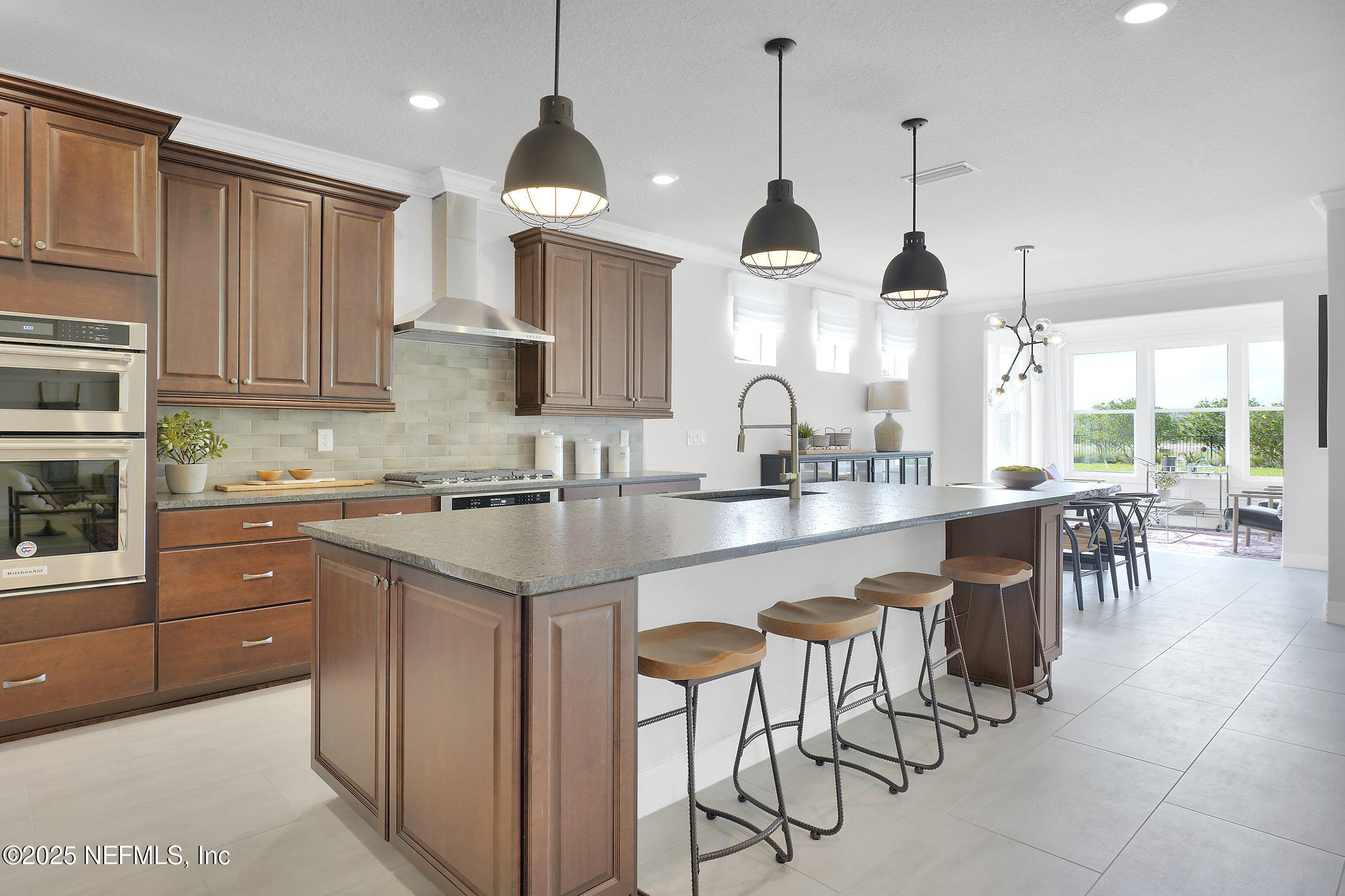 334 Continuum Loop Yulee, FL 32097 - Photo 6 of 37 a kitchen with stainless steel appliances granite countertop wooden cabinets a stove a sink a dining table and chairs