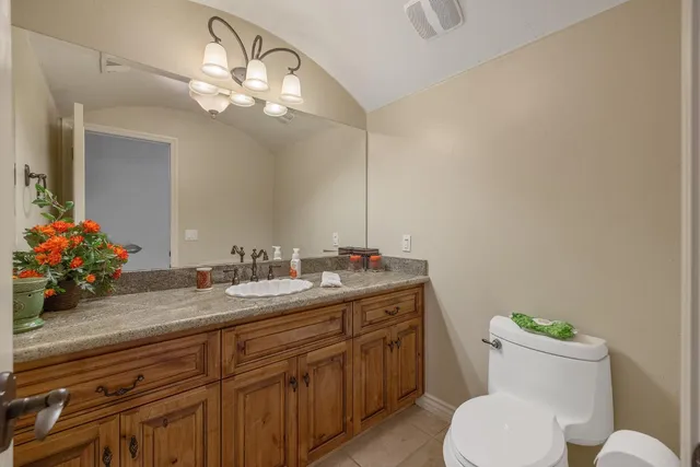 a view of a hallway with wooden floor and a bathroom