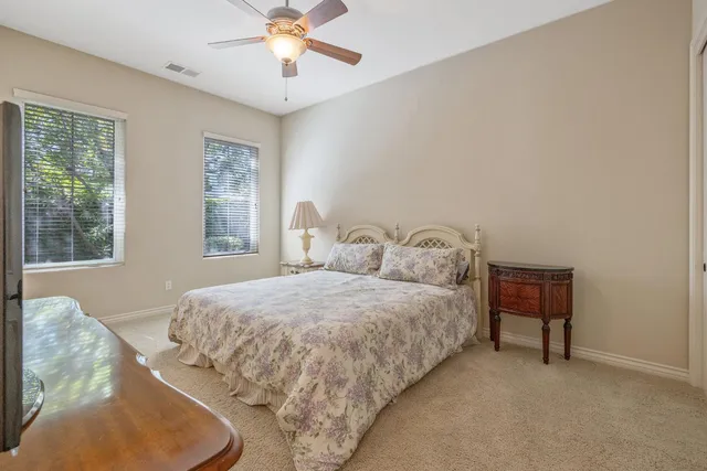 a view of a dining room and livingroom with furniture wooden floor a rug a fireplace and a chandelier