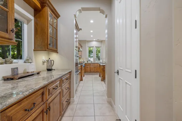 an aerial view of a house with swimming pool and large trees