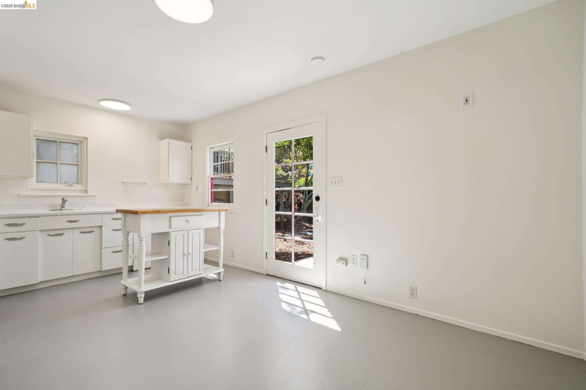 1425 Virginia Street Berkeley, CA 94702 - Photo 34 of 42 a view of a kitchen with white cabinets and wooden floor