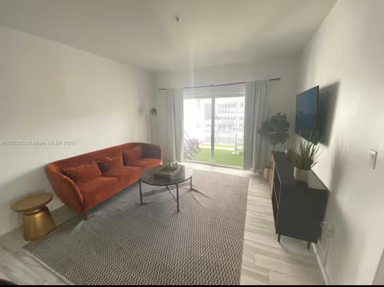 481 Northeast 29th Street, Unit 706 Miami, FL 33137 - Photo 11 of 26 a living room with furniture and a flat screen tv