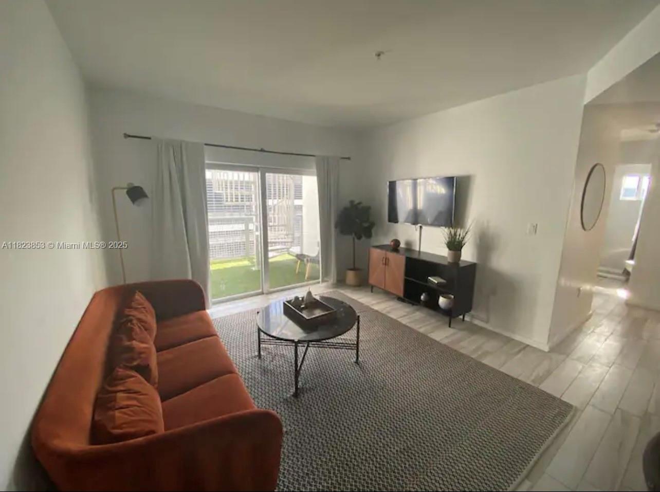 481 Northeast 29th Street, Unit 706 Miami, FL 33137 - Photo 12 of 26 a living room with furniture and a large window