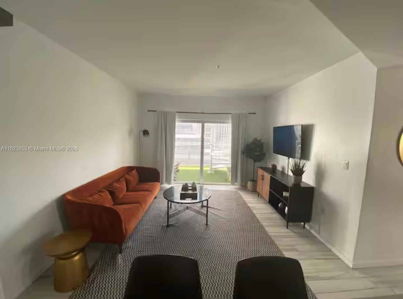 481 Northeast 29th Street, Unit 706 Miami, FL 33137 - Photo 13 of 26 a living room with furniture and a flat screen tv