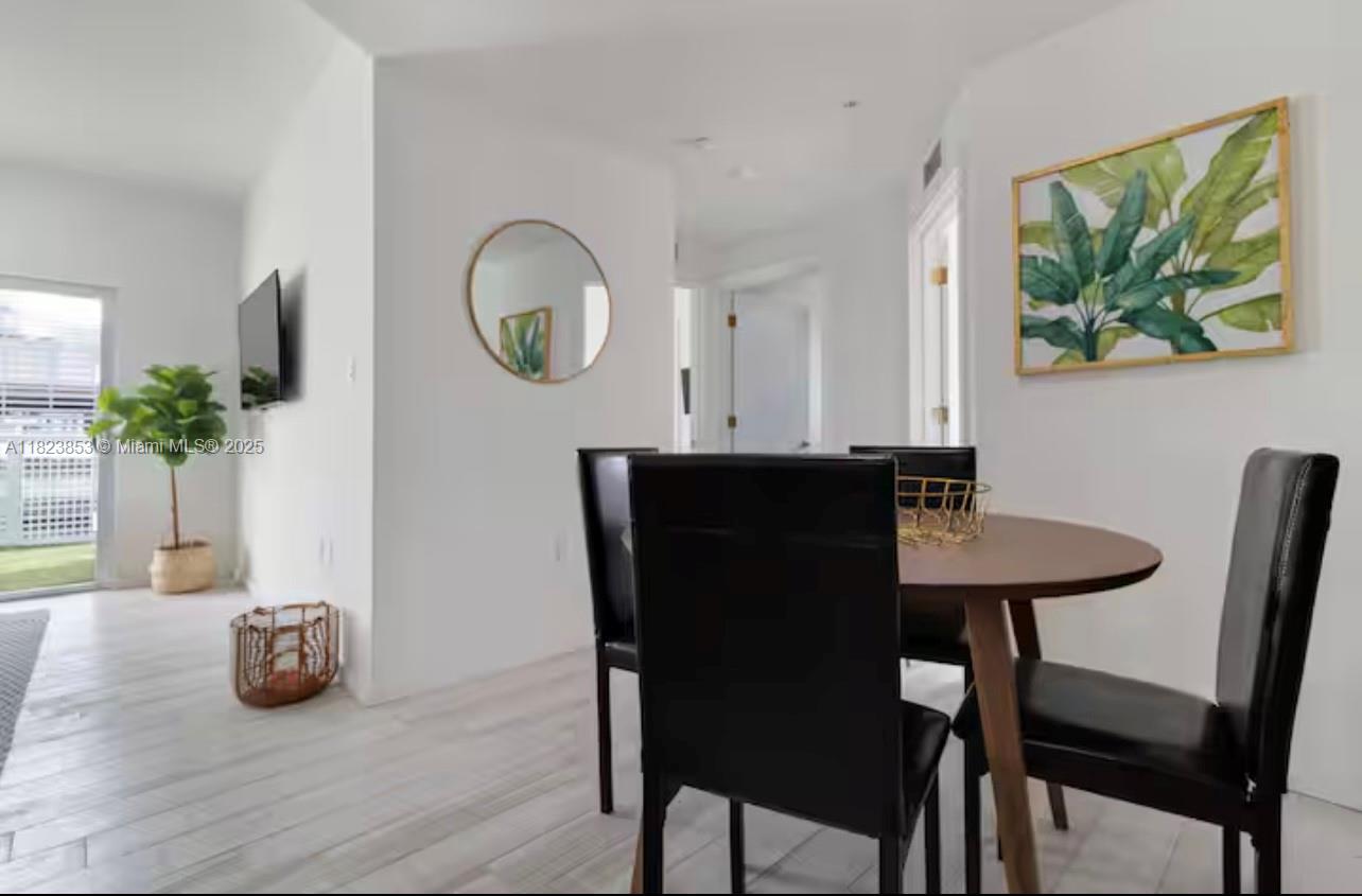 481 Northeast 29th Street, Unit 706 Miami, FL 33137 - Photo 16 of 26 a view of a dining room with furniture and a potted plant