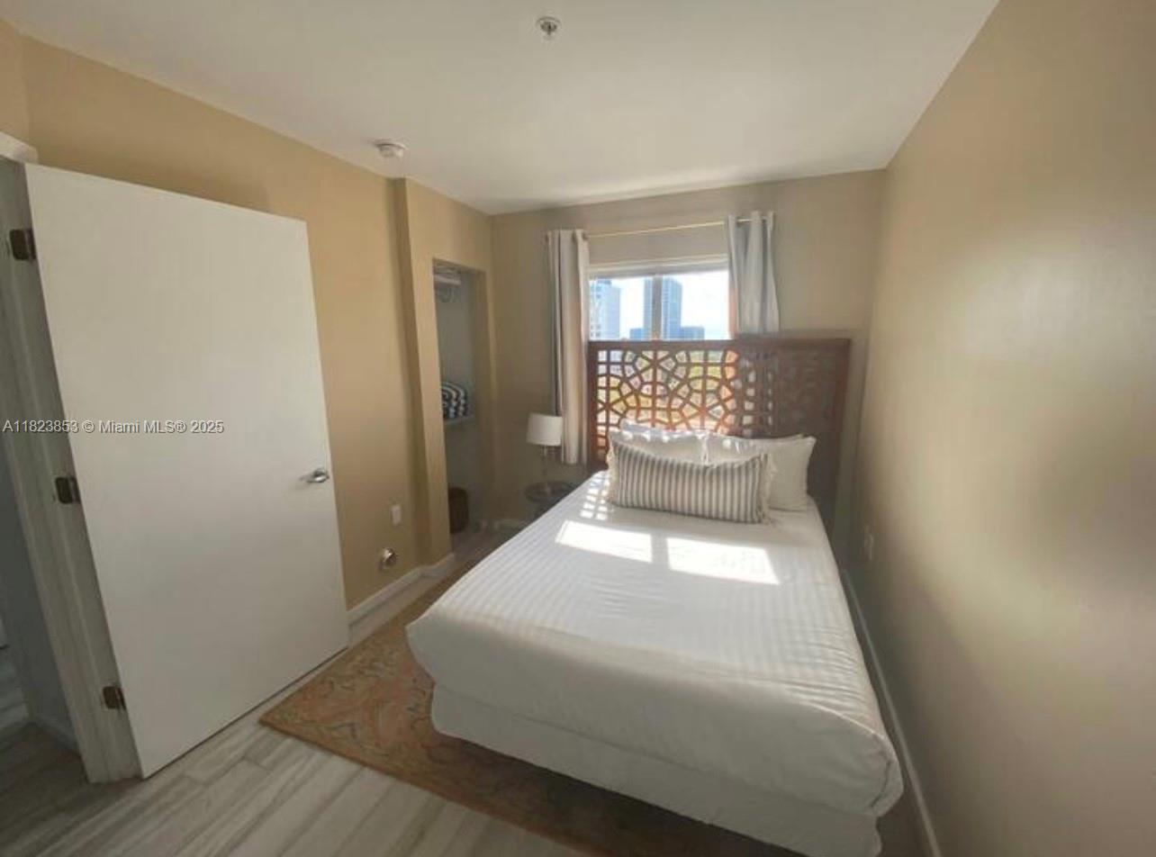 481 Northeast 29th Street, Unit 706 Miami, FL 33137 - Photo 18 of 26 a bedroom with a bed and wooden floor