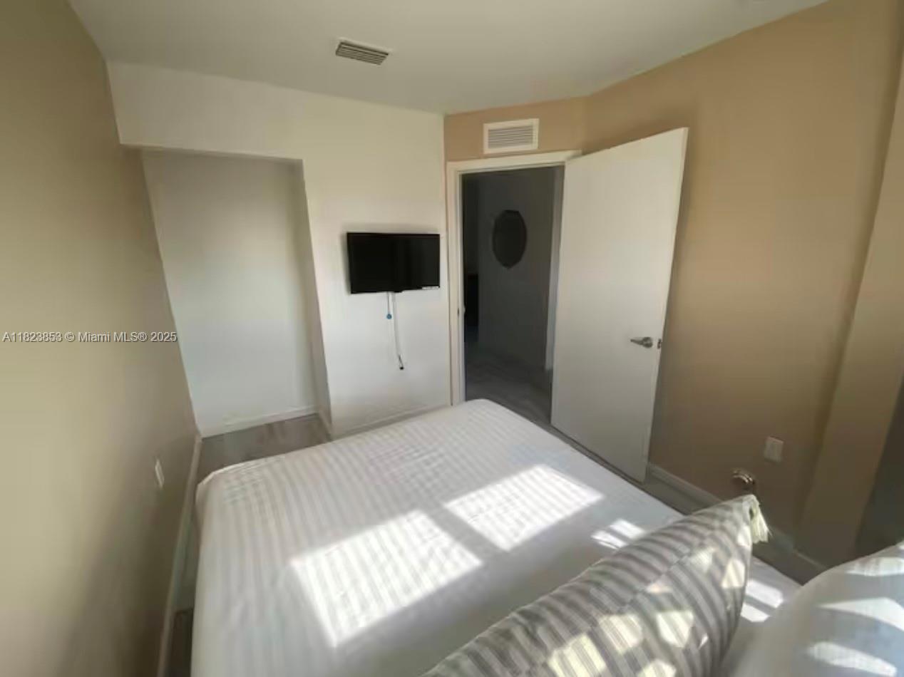 481 Northeast 29th Street, Unit 706 Miami, FL 33137 - Photo 19 of 26 a bedroom with a bed and a flat screen tv