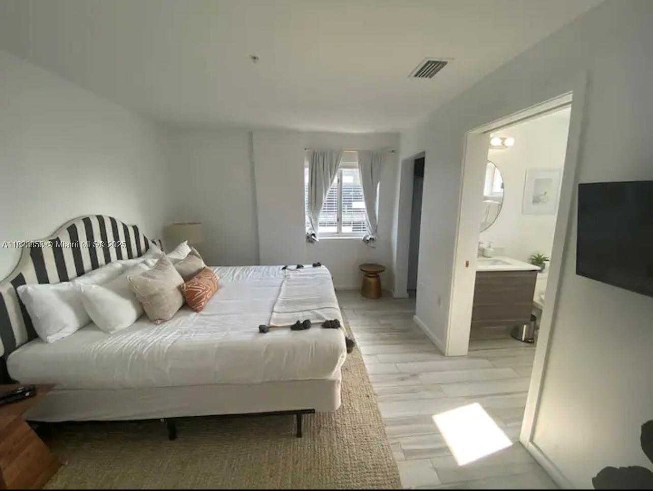 481 Northeast 29th Street, Unit 706 Miami, FL 33137 - Photo 21 of 26 a bedroom with a bed and a couch