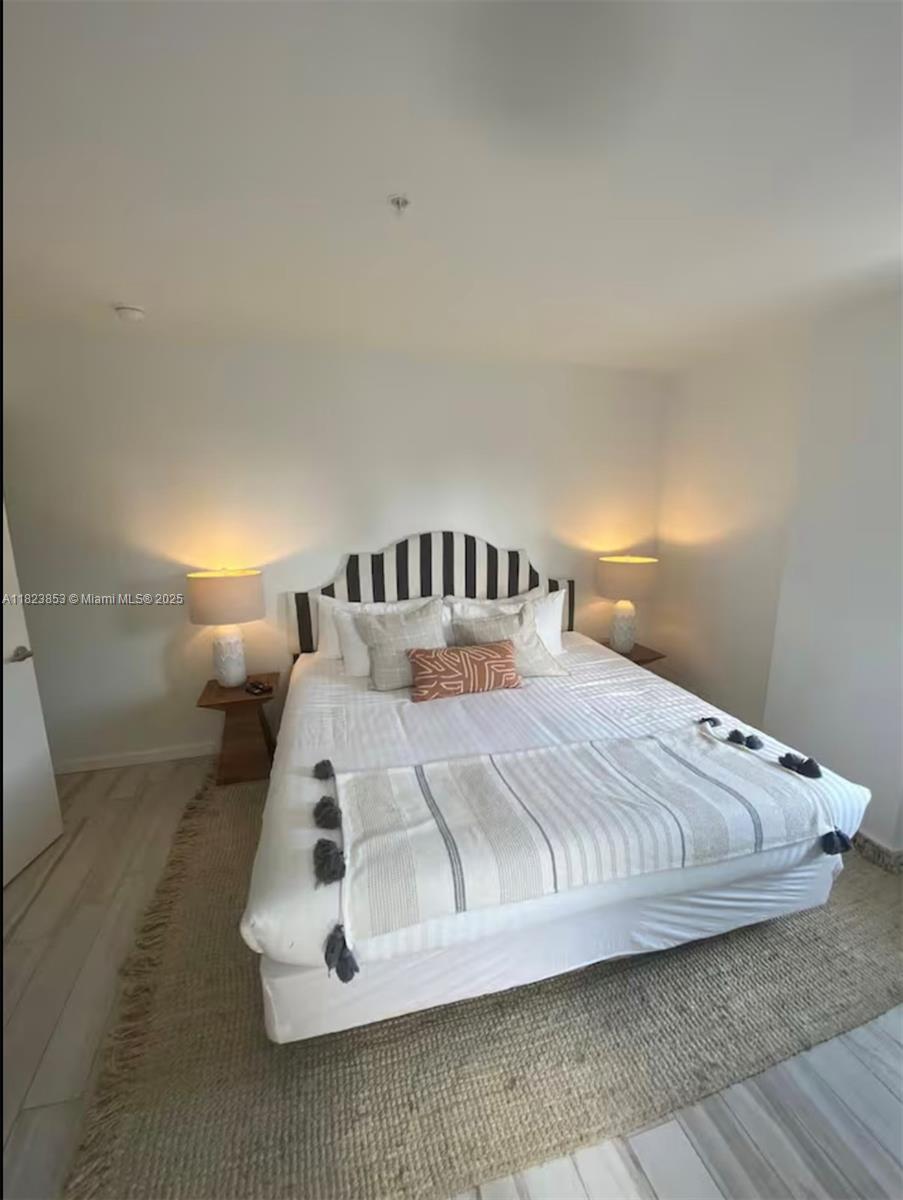 481 Northeast 29th Street, Unit 706 Miami, FL 33137 - Photo 22 of 26 a bed sitting in a room next to a lamp