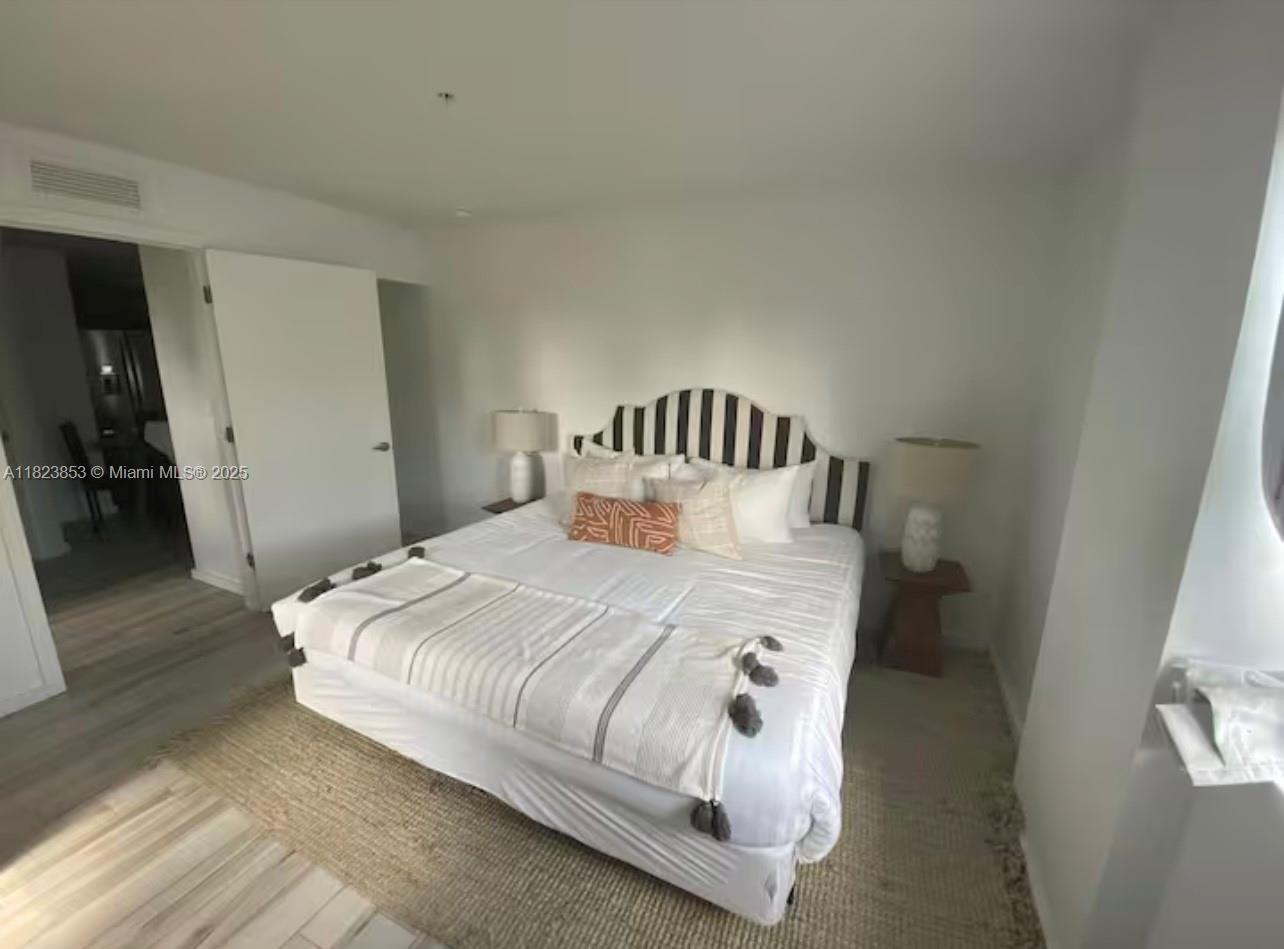 481 Northeast 29th Street, Unit 706 Miami, FL 33137 - Photo 23 of 26 a bedroom with a bed and a mirror