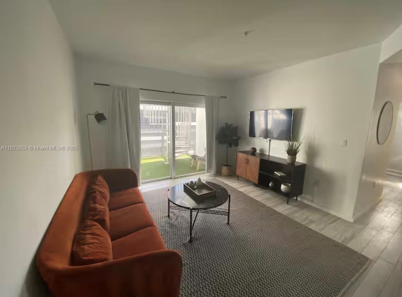 481 Northeast 29th Street, Unit 706 Miami, FL 33137 - Photo 8 of 26 a living room with furniture and a potted plant