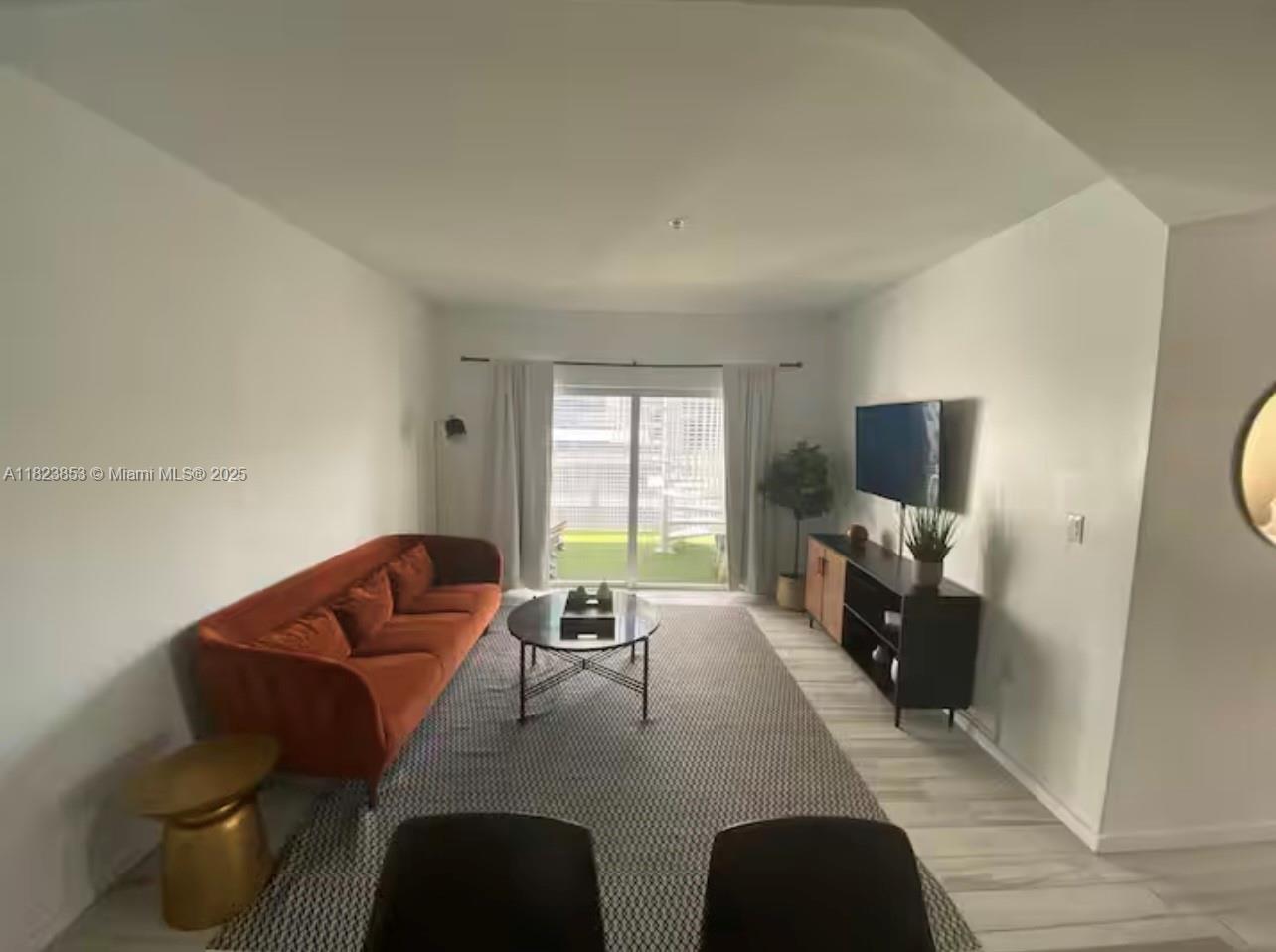 481 Northeast 29th Street, Unit 706 Miami, FL 33137 - Photo 9 of 26 a living room with furniture a flat screen tv and a window