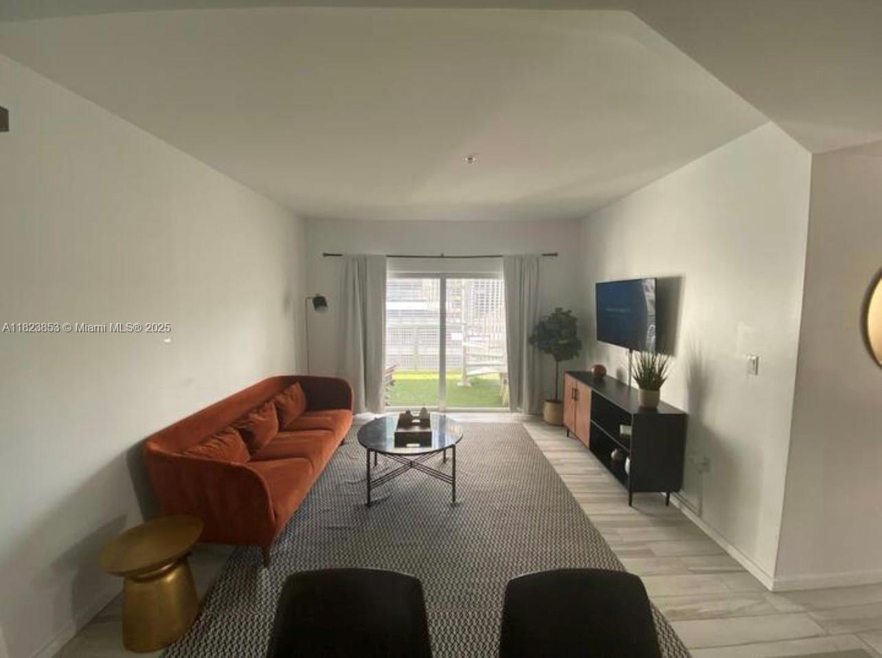 481 Northeast 29th Street, Unit 706 Miami, FL 33137 - Photo 10 of 26 a living room with furniture and a flat screen tv