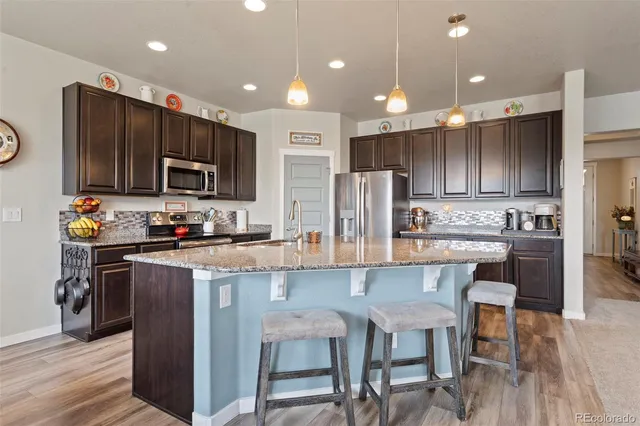 a kitchen with kitchen island granite countertop wooden cabinets and stainless steel appliances