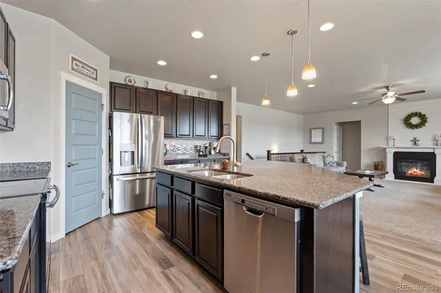 a kitchen with stainless steel appliances granite countertop a sink a stove and refrigerator