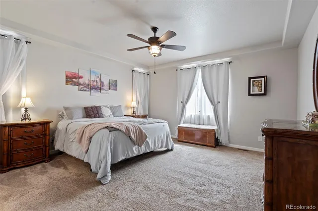 a spacious bedroom with a bed and a chandelier