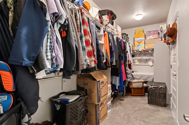 a view of walk in closet with clothes and shoes