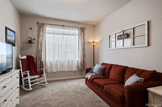 a living room with furniture a air conditioner and a window