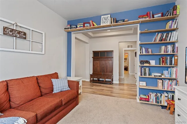 a living room with furniture and a book shelf