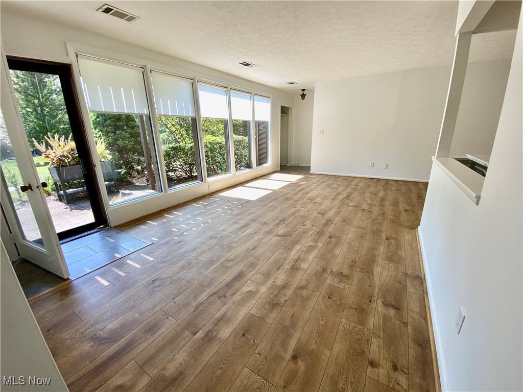 985 Canyon View Road, Unit 102B Northfield, OH 44067 - Photo 5 of 32 Unfurnished living room featuring a textured ceiling and wood-type flooring