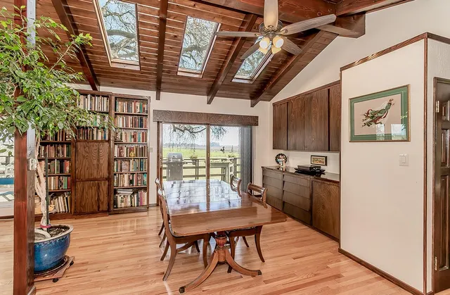 a room with a desk chairs and white appliances