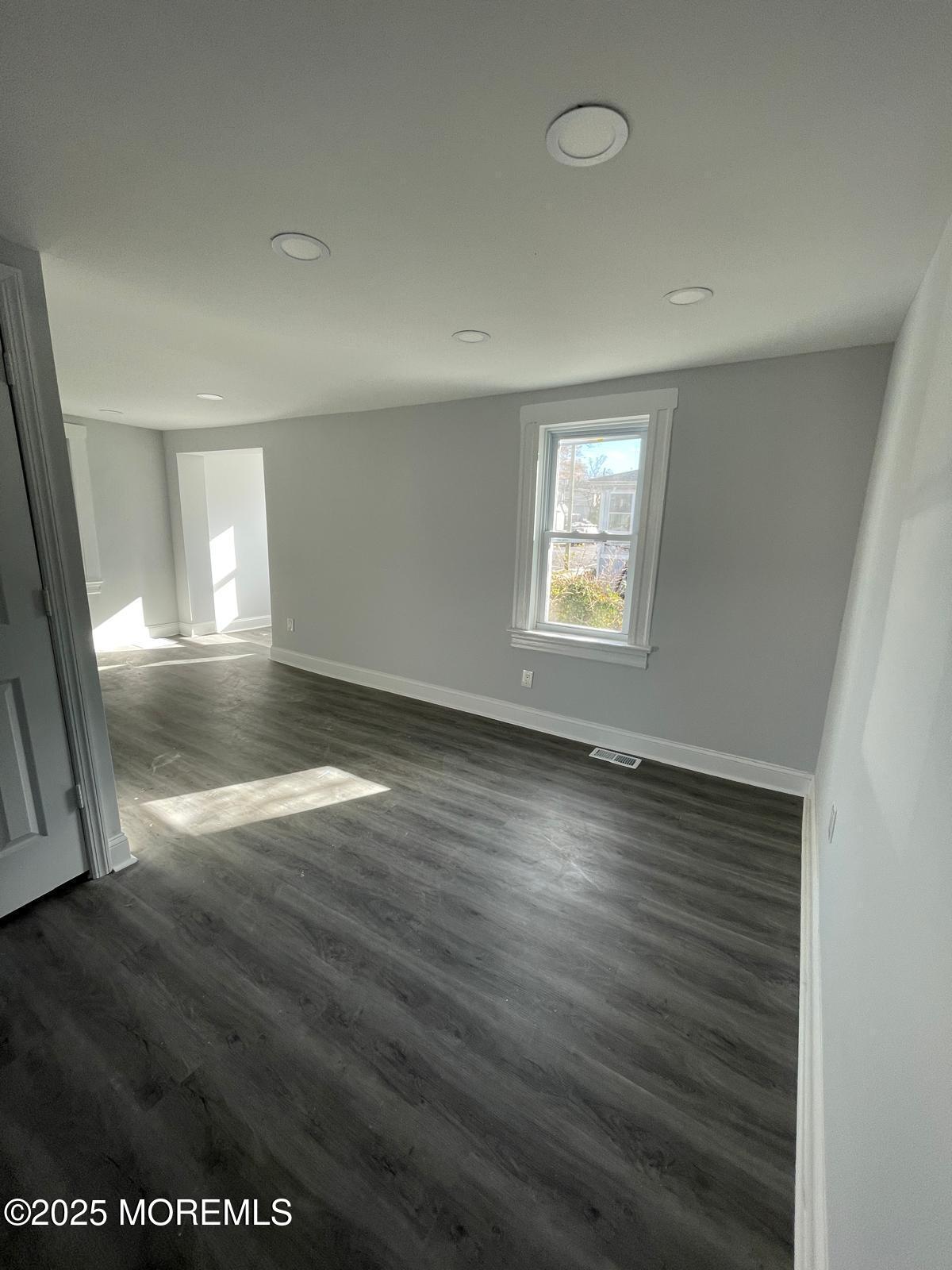 405 Myrtle Avenue Neptune Township, NJ 07753 - Photo 15 of 20 an empty room with wooden floor and windows