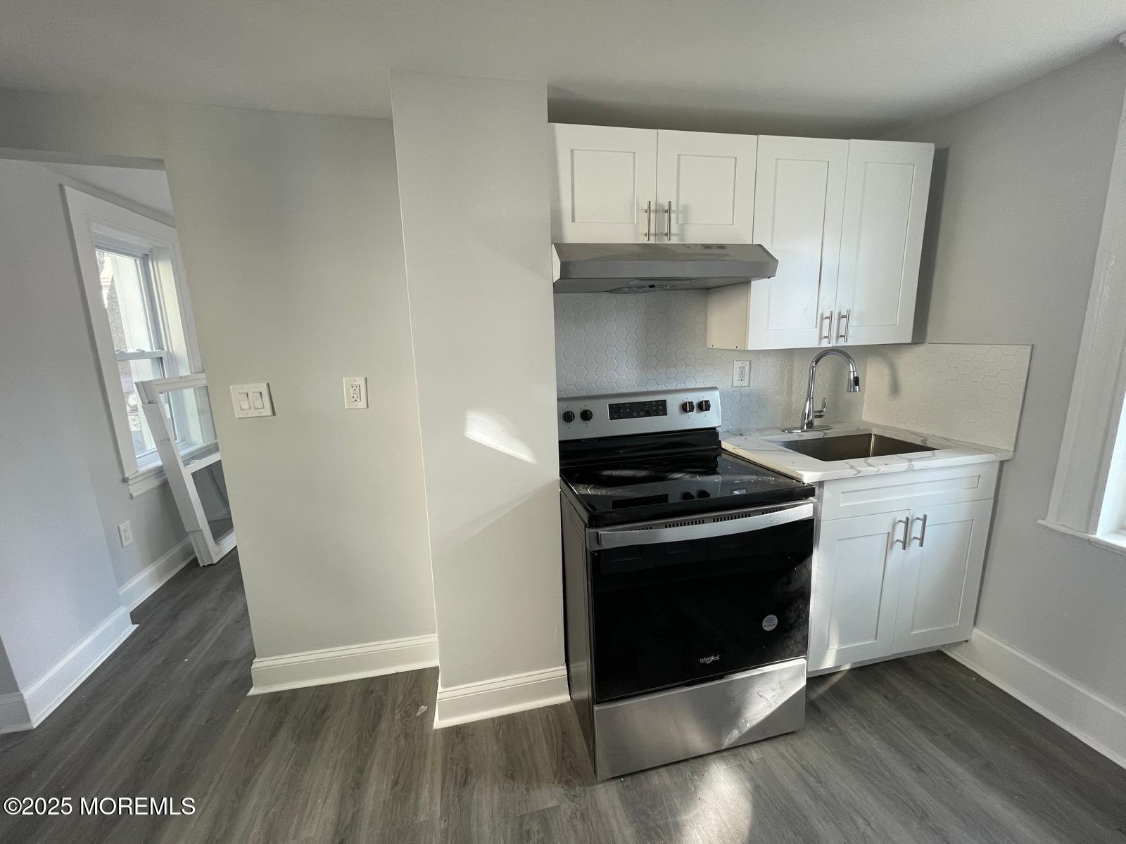 405 Myrtle Avenue Neptune Township, NJ 07753 - Photo 6 of 20 a kitchen with granite countertop wooden floors and stainless steel appliances