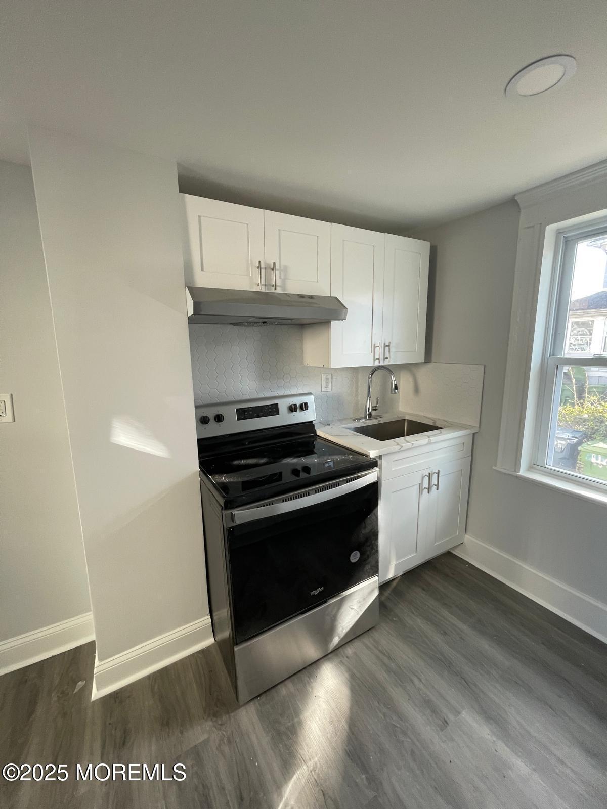 405 Myrtle Avenue Neptune Township, NJ 07753 - Photo 7 of 20 a kitchen with stainless steel appliances a stove a sink and a refrigerator
