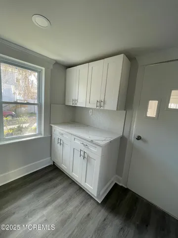 a kitchen with cabinets stove and a window