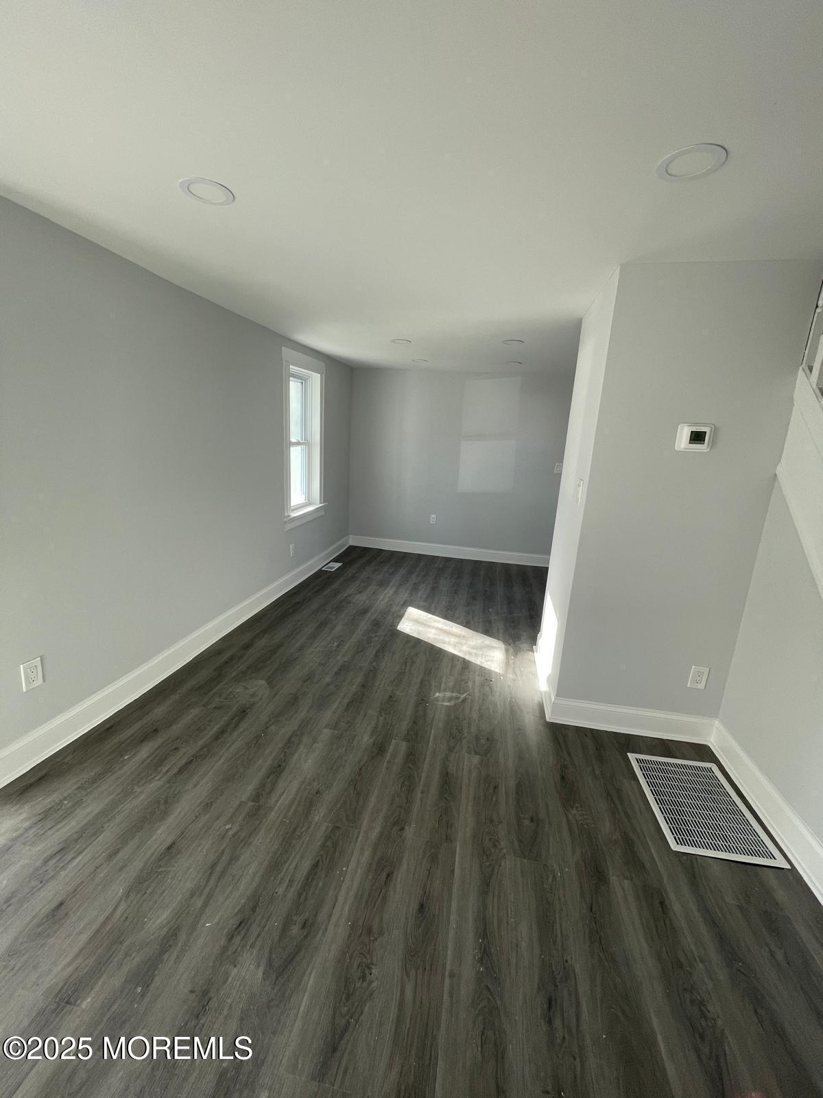 405 Myrtle Avenue Neptune Township, NJ 07753 - Photo 10 of 20 an empty room with wooden floor and windows