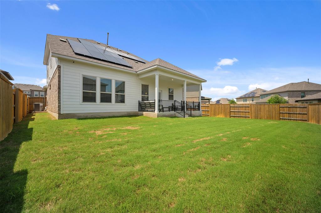 265 Fawn Riv Run Kyle, TX 78640 - Photo 35 of 39 Green grass stretches across a level backyard enclosed by a wooden privacy fence.