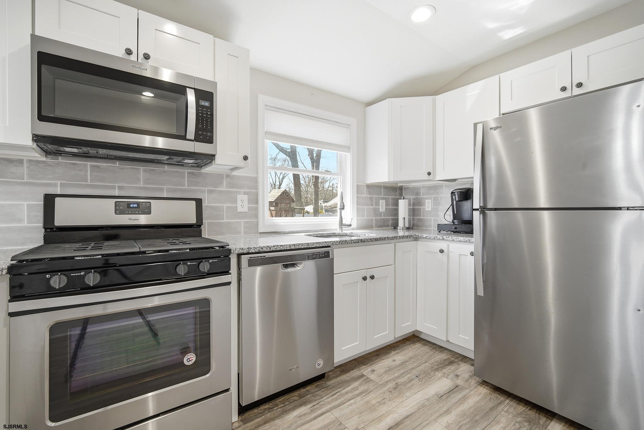 1103 Chelsea Road Absecon, NJ 08201 - Photo 12 of 34 a kitchen with cabinets stainless steel appliances and wooden floor