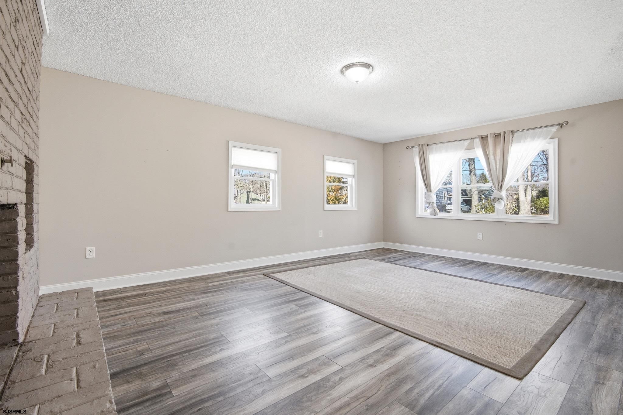 1103 Chelsea Road Absecon, NJ 08201 - Photo 16 of 34 an empty room with wooden floor and windows