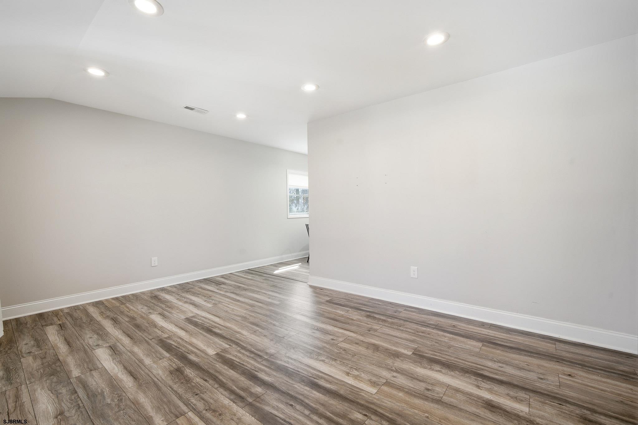 1103 Chelsea Road Absecon, NJ 08201 - Photo 6 of 34 an empty room with wooden floor and windows