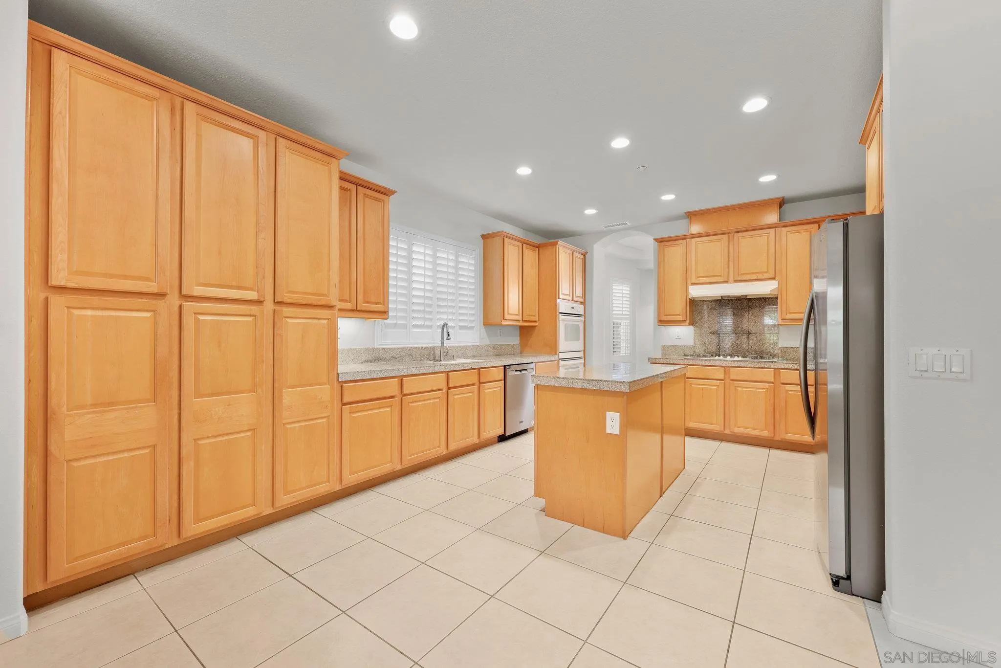 824 Hillcrest Terrace Fallbrook, CA 92028 - Photo 9 of 47 a large kitchen with kitchen island granite countertop wooden cabinets a granite counter tops and a window